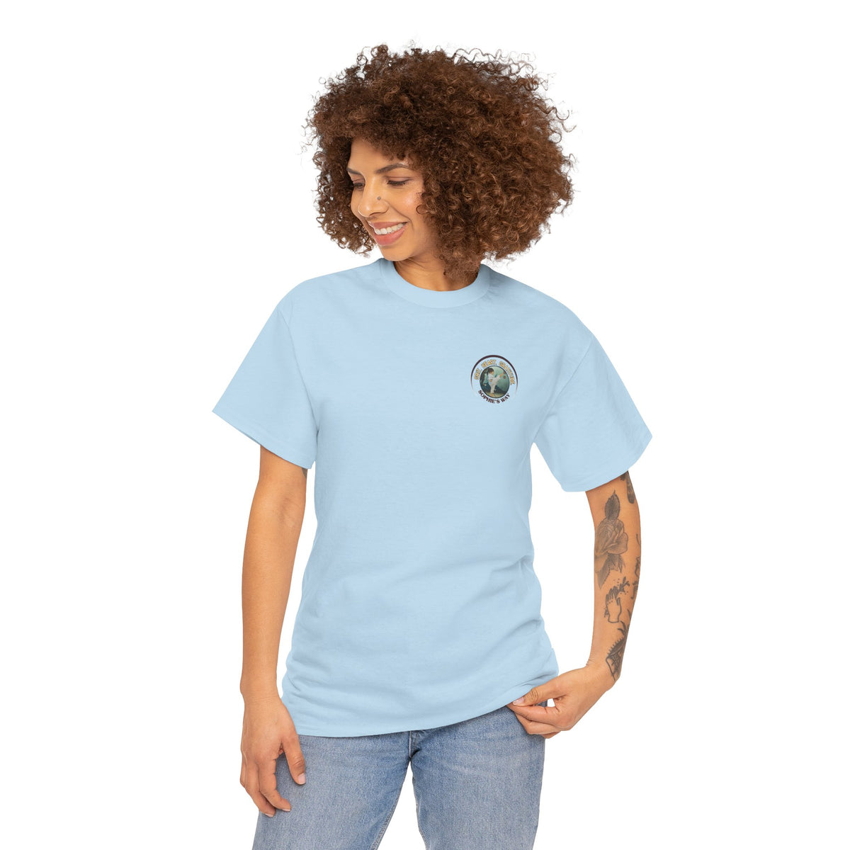 Light blue colored t-shirt with a small round logo of a taekwondo girl doing a side kick and the words Grit. Heart. Gratitude. Sophie's Way.