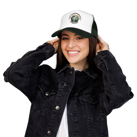 A forest green and white trucker hat with a circular graphic on the front panel. The graphic features a border with the words 'Grit. Heart. Gratitude. Sophie's Way' and a taekwondo tot doing a side kick in the center.