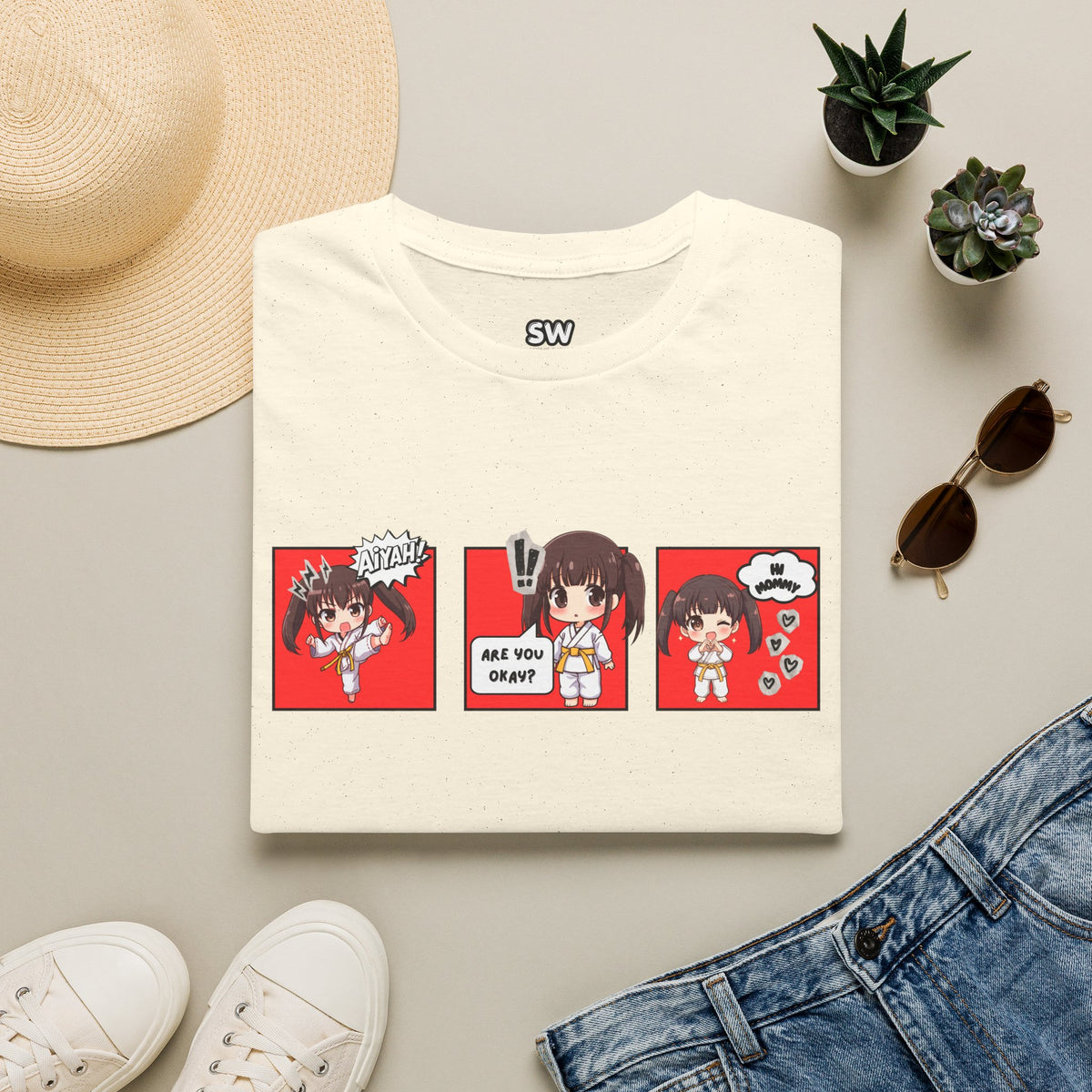 Are You Okay? unisex softstyle t-shirt in natural/cream with chibi taekwondo girl three-panel comic strip graphic — "Aiyah!", "Are You Okay?", "Hi Mommy"