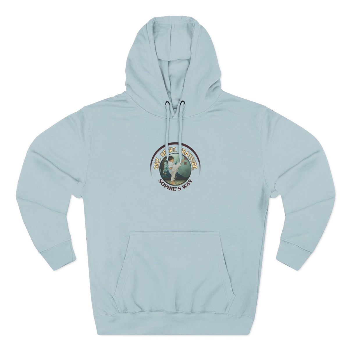 A blue mist pullover hoodie with a circular graphic on the chest that reads 'Grit. Heart. Gratitude. Sophie's Way' around a globe design around a taekwondo tot doing a side kick. The hoodie features a drawstring hood, long sleeves, and a front kangaroo pocket.