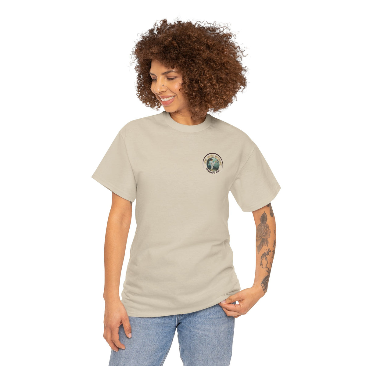 Sand colored t-shirt with a small round logo of a taekwondo girl doing a side kick and the words Grit. Heart. Gratitude. Sophie's Way.