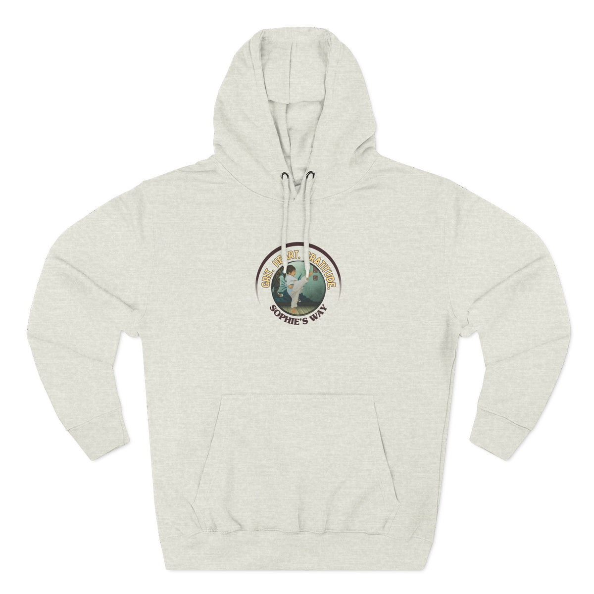 A oatmeal heather pullover hoodie with a circular graphic on the chest that reads 'Grit. Heart. Gratitude. Sophie's Way' around a globe design around a taekwondo tot doing a side kick. The hoodie features a drawstring hood, long sleeves, and a front kangaroo pocket.