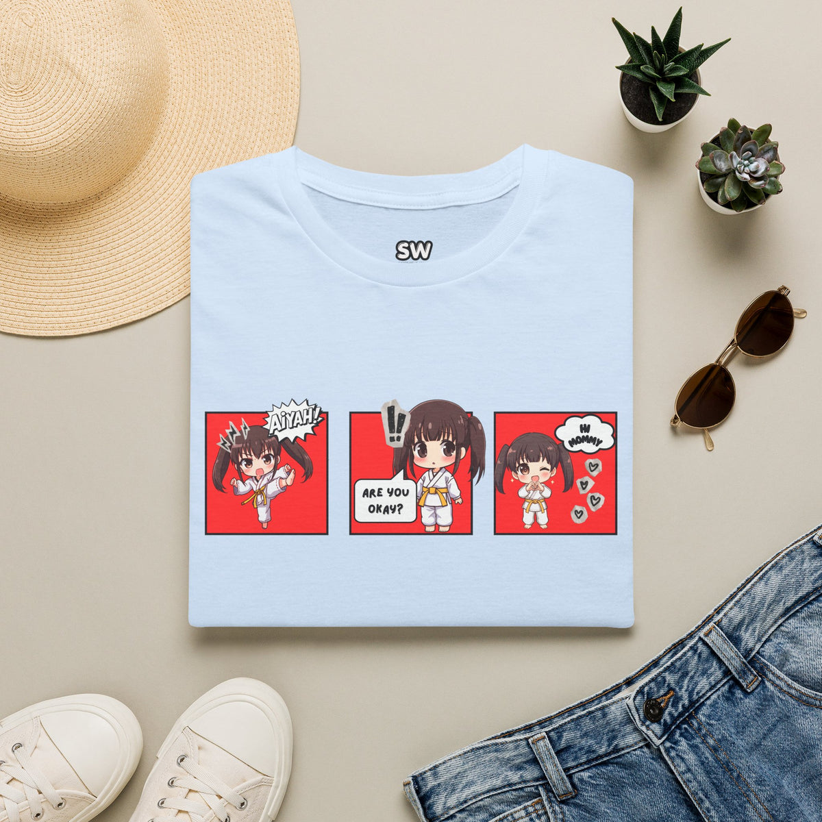 Are You Okay? unisex softstyle t-shirt in light blue with chibi taekwondo girl three-panel comic strip graphic — "Aiyah!", "Are You Okay?", "Hi Mommy"
